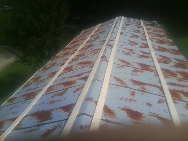 Rusted metal roof panels with new wood purlins before replacement — Storm Damage Roof Repair in Oneida by Roofing Brothers